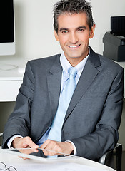 Image showing Businessman With Digital Tablet Sitting At Desk