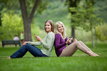 Image showing Female Friends With Cellphones In Park