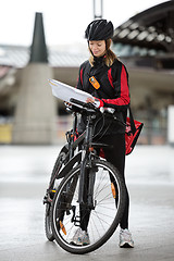 Image showing Female Cyclist With Courier Bag And Package On Street