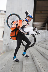 Image showing Courier Delivery Man With Bicycle And Backpack Walking Up Stairs