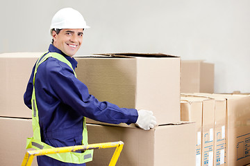 Image showing Foreman Holding Cardboard Box in Warehouse