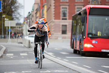 Image showing Courier Delivery Man Using Walkie-Talkie While Riding Bicycle On