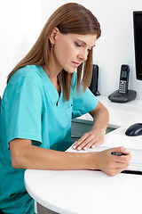 Image showing Dentist Analyzing Report In Clinic