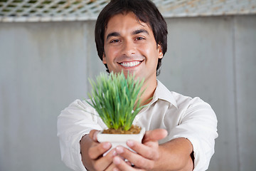 Image showing Happy Man Holding Plant