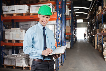 Image showing Confident Supervisor With Book At Warehouse