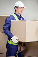 Image showing Foreman Lifting Cardboard Box At Warehouse