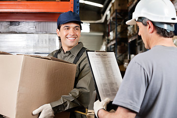 Image showing Warehouse Worker Looking At Supervisor With Clipboard