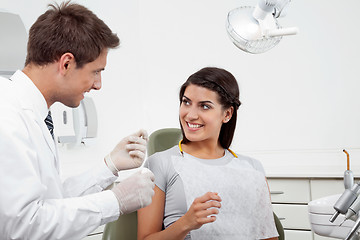 Image showing Dentist Holding Thread While Patient Looking At Him