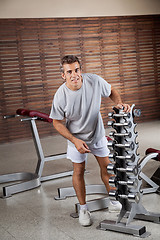 Image showing Man Standing By Dumbbells In Rack