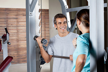 Image showing Man Lifting Weights While Looking At Instructor