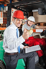 Image showing Supervisor And Forklift Driver Gesturing Thumbs Up