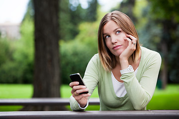 Image showing Thoughtful Woman holding Cell Phone