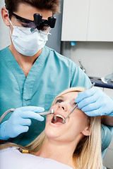 Image showing Dentist Treating A Female Patient At Clinic