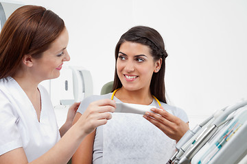 Image showing Female Dentist Prescribing Tooth Paste To Patient