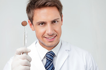 Image showing Dentist Holding Angled Mirror And Carver