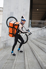 Image showing Male Cyclist With Courier Bag And Bicycle Walking Up Steps