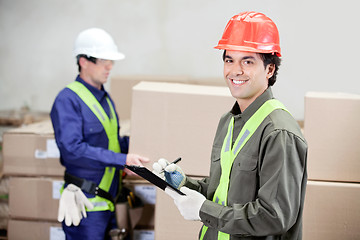 Image showing Supervisor Writing Notes Clipboard While Foreman Working At Ware