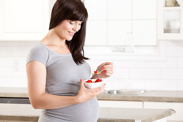 Image showing Pregnant Woman in Kitchen Eating Healthy Snack