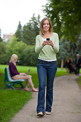 Image showing Woman Reading Text Message In Park