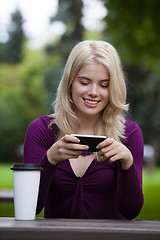 Image showing Woman Updating Status on Mobile Phone