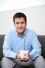 Image showing Businessman Holding Piggybank