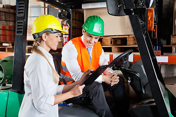 Image showing Supervisor Showing Clipboard To Colleague Sitting In Forklift