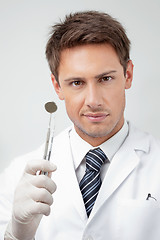 Image showing Young Male Dentist Holding Tools