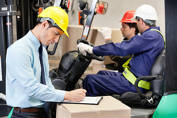 Image showing Male Supervisor Writing On Clipboard At Warehouse