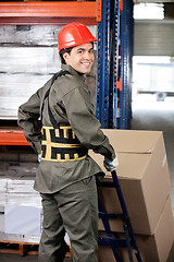 Image showing Warehouse Worker Pushing Handtruck