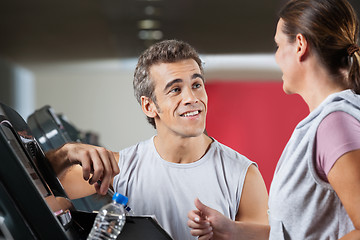 Image showing Instructor Looking At Female Client Exercising On Treadmill