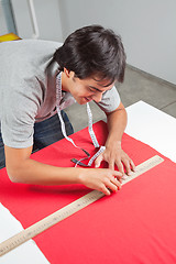 Image showing Dressmaker Measuring Red Fabric
