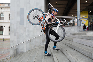 Image showing Male Cyclist With Bicycle On His Shoulder Walking Up Steps