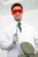 Image showing Young Dentist Holding Tools