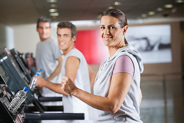 Image showing Woman And Men Running On Treadmill In Fitness Center