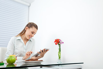 Image showing Businesswoman At Breakfast Table Using Tablet PC