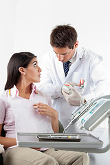 Image showing Dentist Using Teeth Model While Explaining Dental Procedure