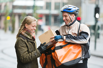 Image showing Young Woman Receiving A Package From Courier Delivery Man