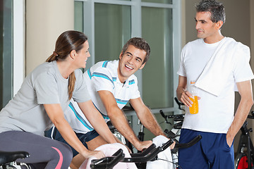 Image showing Man Looking At Happy Friends Exercising On Spinning Bike