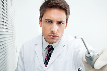 Image showing Dentist Holding Water Spraying Tool