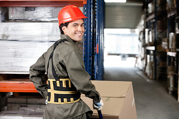 Image showing Warehouse Worker Pushing Handtruck With Cardboard Boxes