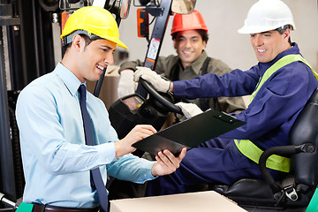 Image showing Male Supervisor Communicating With Forklift Driver And Foreman