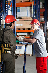 Image showing Foreman Communicating With Coworker At Warehouse