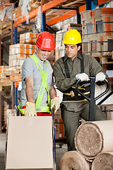 Image showing Foreman Showing Something To Coworker At Warehouse