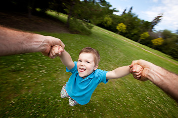 Image showing Father Spinning Son Outdoors in Park