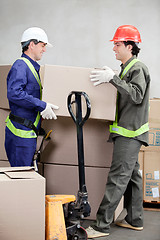 Image showing Foremen Lifting Cardboard Box At Warehouse