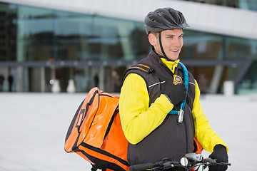 Image showing Male Cyclist With Courier Delivery Bag Using Walkie-Talkie