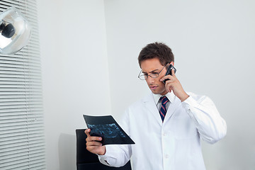 Image showing Male Dentist With X-Ray Using Mobile Phone