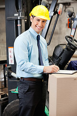 Image showing Young Supervisor Writing On Clipboard At Warehouse