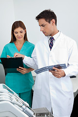Image showing Doctor And Assistant Analyzing Patient's Report