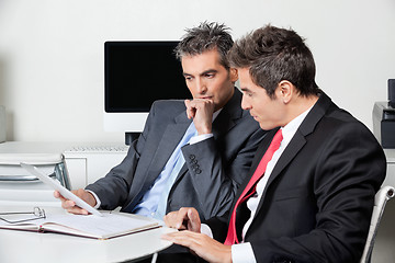 Image showing Thoughtful Businessmen Using Digital Tablet At Desk